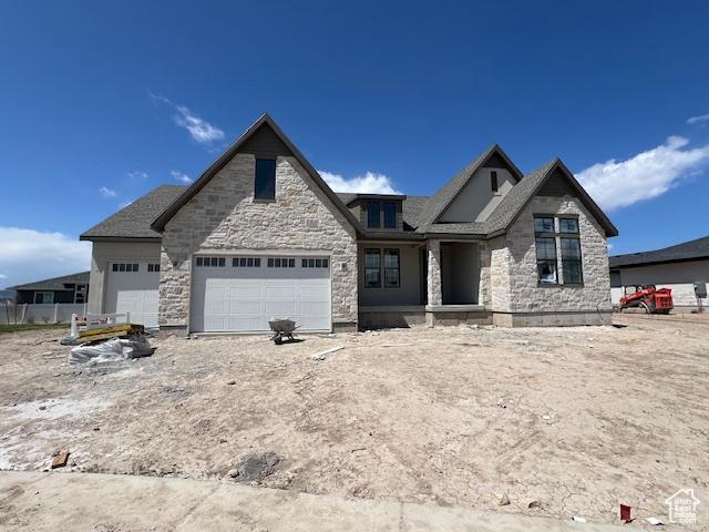 craftsman house featuring stone siding and a garage