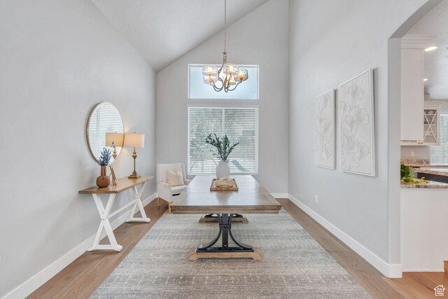 11702 S Water Brook Ct, South Jordan, UT 84095 - interior space with high vaulted ceiling, arched walkways, light wood finished floors, baseboards, and a chandelier