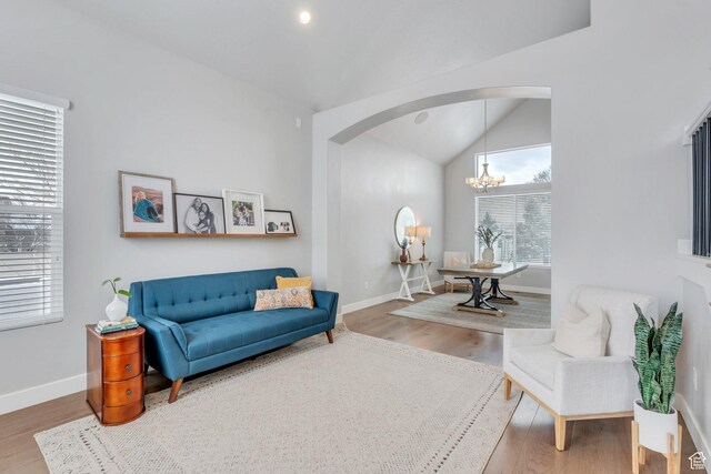 11702 S Water Brook Ct, South Jordan, UT 84095 - sitting room featuring baseboards, lofted ceiling, wood finished floors, arched walkways, and a notable chandelier