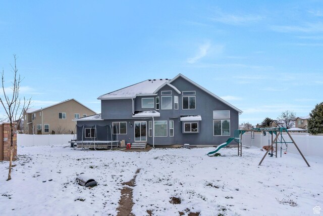 11702 S Water Brook Ct, South Jordan, UT 84095 - snow covered back of property with stucco siding, a playground, a trampoline, and fence
