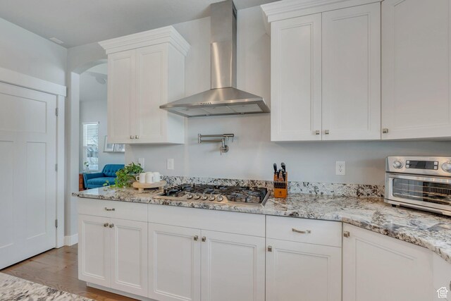 11702 S Water Brook Ct, South Jordan, UT 84095 - kitchen featuring white cabinets, wall chimney exhaust hood, light wood-type flooring, and stainless steel gas cooktop