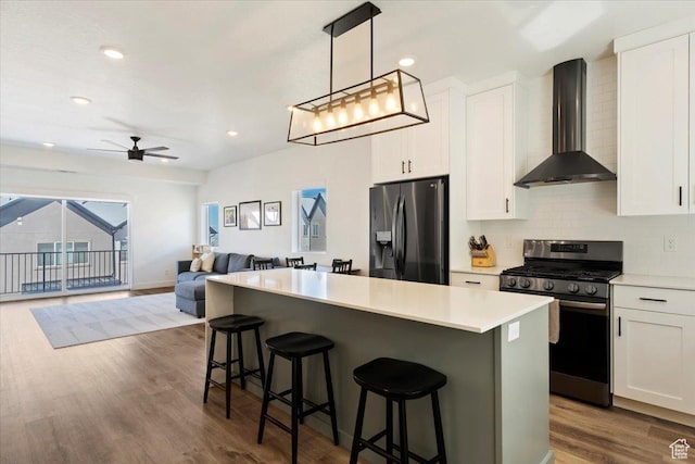 51 E Vantage Dr, North Salt Lake, UT 84054 - kitchen featuring appliances with stainless steel finishes, wall chimney exhaust hood, open floor plan, white cabinetry, and a kitchen island