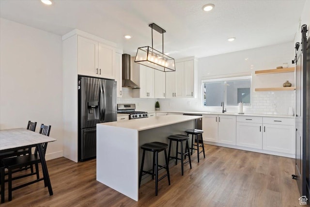 51 E Vantage Dr, North Salt Lake, UT 84054 - kitchen featuring stainless steel appliances, wall chimney range hood, decorative backsplash, a kitchen bar, and recessed lighting