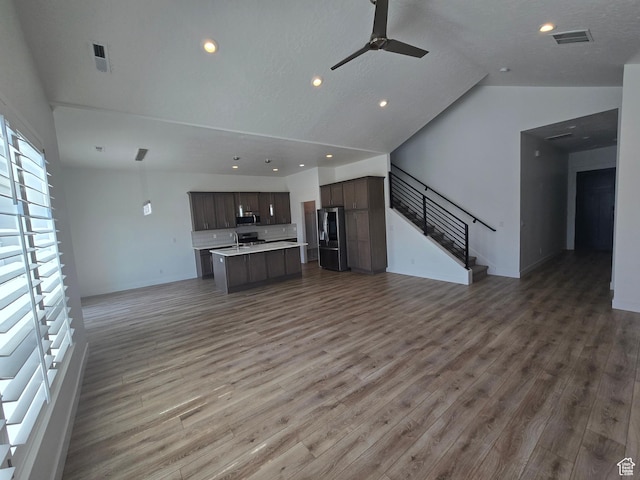 10717 S Haven Vista Dr, South Jordan, UT 84095 - unfurnished living room featuring stairs, lofted ceiling, a ceiling fan, and wood finished floors