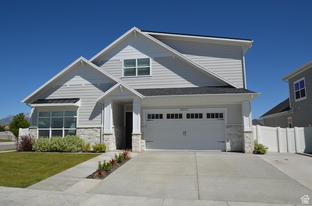10717 S Haven Vista Dr, South Jordan, UT 84095 - view of front of home featuring stone siding, an attached garage, concrete driveway, and fence