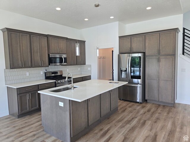 10717 S Haven Vista Dr, South Jordan, UT 84095 - kitchen featuring dark brown cabinets, light wood-style floors, appliances with stainless steel finishes, and a sink