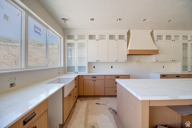 608 E 1310 S, Payson, UT 84651 - kitchen featuring premium range hood, light stone counters, glass insert cabinets, white cabinetry, and a textured ceiling