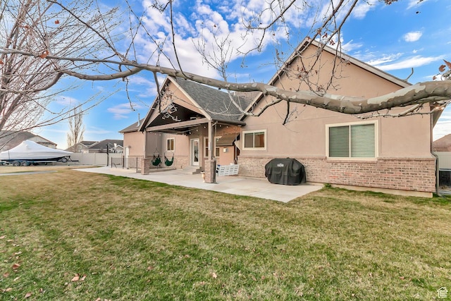 3857 S Windlass Rd W, Saratoga Springs, UT 84045 - back of house featuring a yard, brick siding, a patio area, and stucco siding
