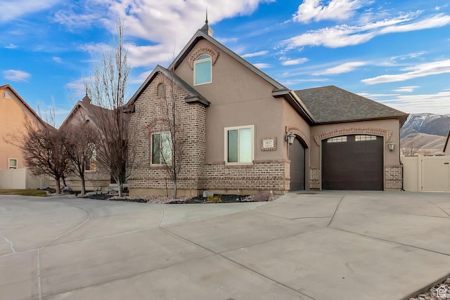 3857 S Windlass Rd W, Saratoga Springs, UT 84045 - view of front of home featuring concrete driveway, brick siding, an attached garage, and roof with shingles