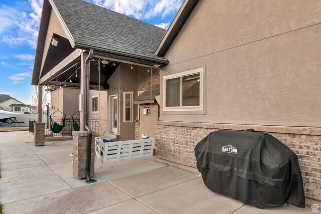3857 S Windlass Rd W, Saratoga Springs, UT 84045 - exterior space with a shingled roof, a patio area, and stucco siding
