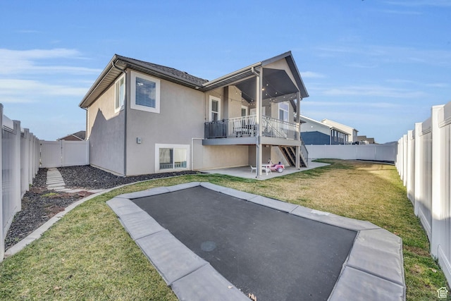 571 S 3350 W, Syracuse, UT 84075 - back of property with a trampoline, stucco siding, a lawn, a fenced backyard, and a patio area