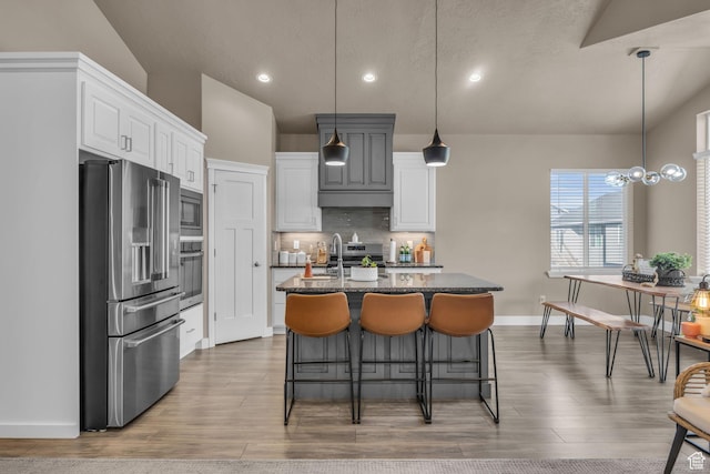 571 S 3350 W, Syracuse, UT 84075 - kitchen featuring dark stone counters, a kitchen island with sink, appliances with stainless steel finishes, white cabinetry, and tasteful backsplash