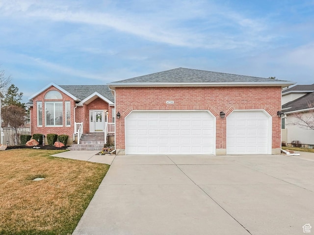 view of front of home with fence, concrete driveway, a front lawn, a garage, and brick siding