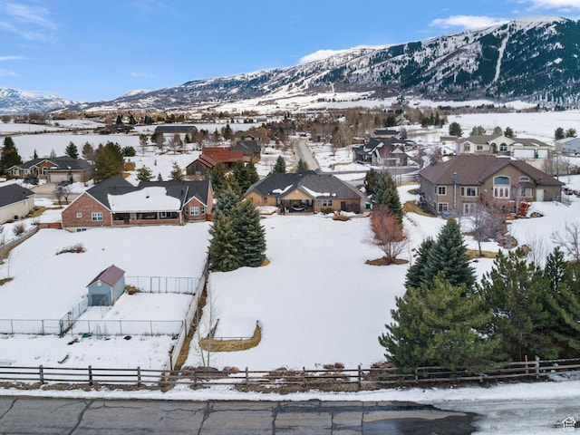 snowy aerial view with a mountain view and a residential view