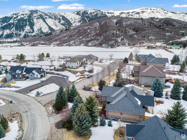 snowy aerial view featuring a residential view and a mountain view