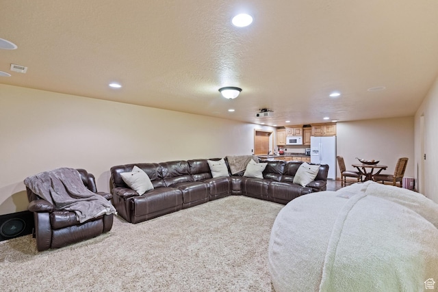 carpeted living area with visible vents and recessed lighting