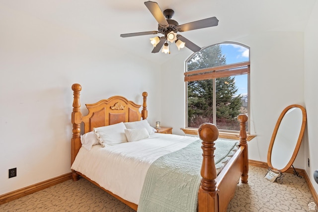 bedroom featuring light carpet, a ceiling fan, baseboards, and vaulted ceiling