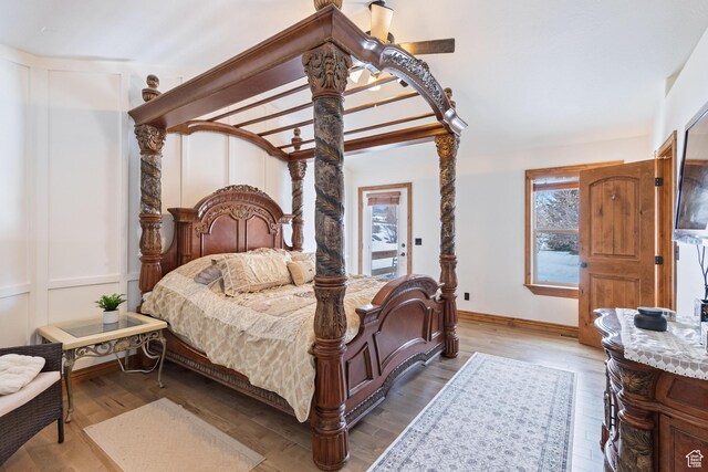 bedroom with a decorative wall and wood finished floors