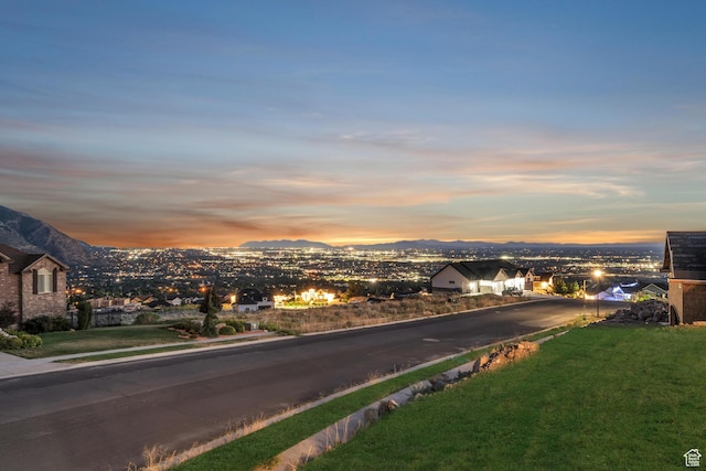 view of street with curbs, a mountain view, and sidewalks