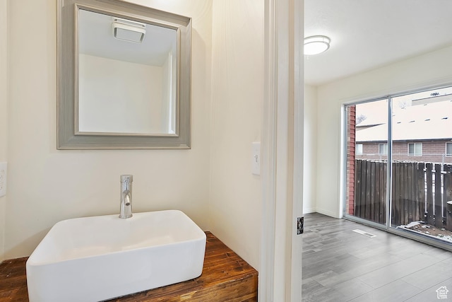 bathroom featuring visible vents, wood finished floors, and a sink