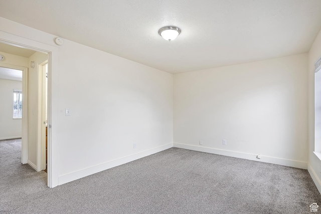 spare room featuring baseboards and carpet