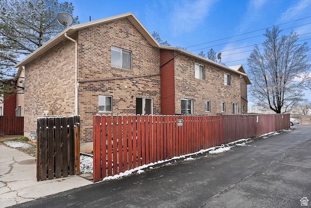 view of home's exterior with brick siding and fence
