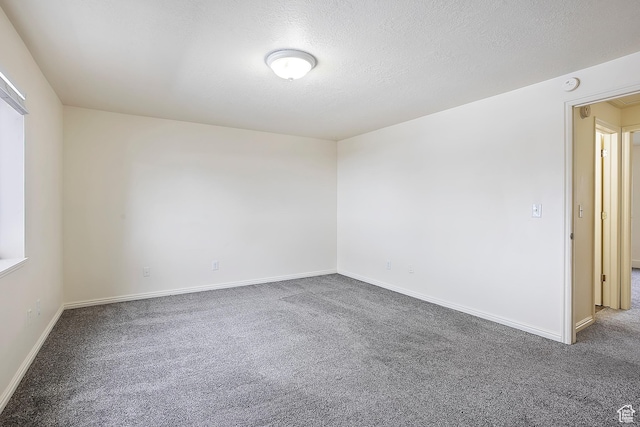 unfurnished room featuring carpet flooring, a textured ceiling, and baseboards