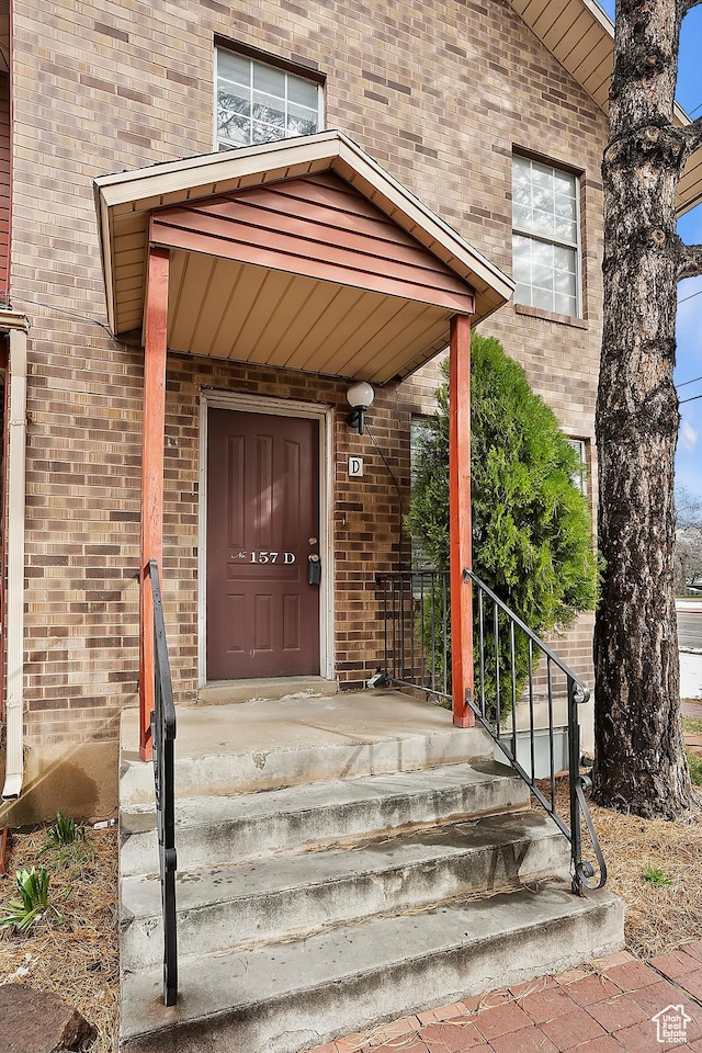 doorway to property featuring brick siding