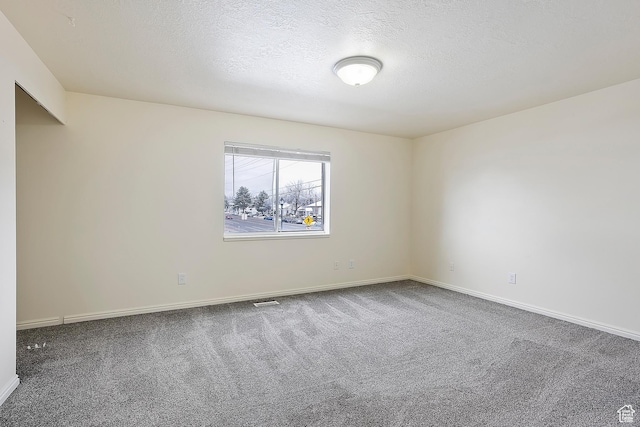 unfurnished room with baseboards, a textured ceiling, and carpet