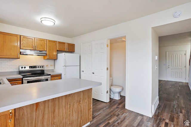 kitchen with under cabinet range hood, electric stove, light countertops, and freestanding refrigerator