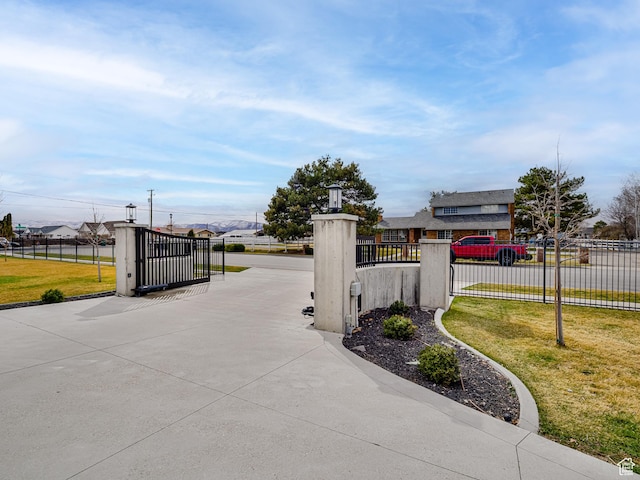 exterior space featuring a residential view, driveway, a gate, and a gated entry