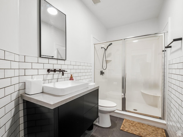 bathroom featuring tile walls, toilet, and a stall shower
