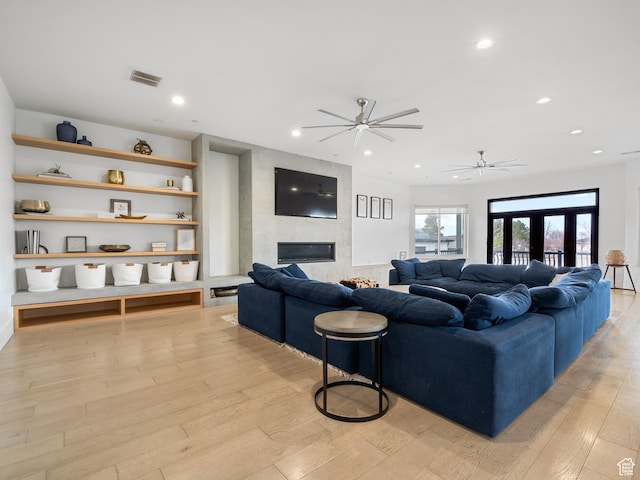 living room featuring recessed lighting, ceiling fan, light wood-style flooring, visible vents, and a fireplace