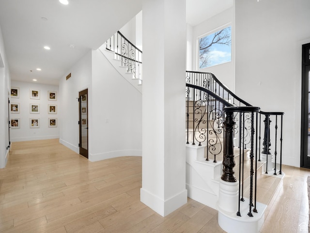 staircase with baseboards, wood finished floors, and recessed lighting