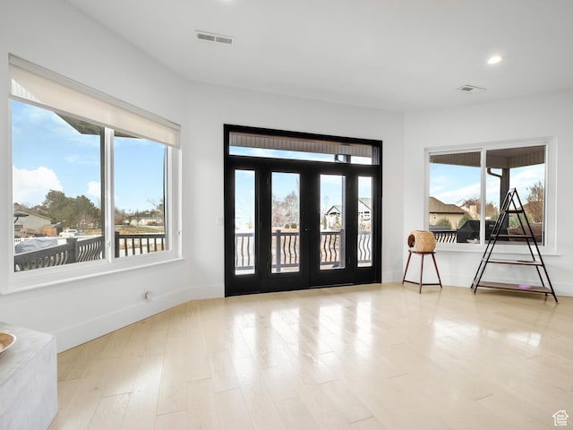 entryway featuring baseboards, visible vents, wood finished floors, and recessed lighting