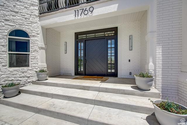 property entrance with brick siding and covered porch