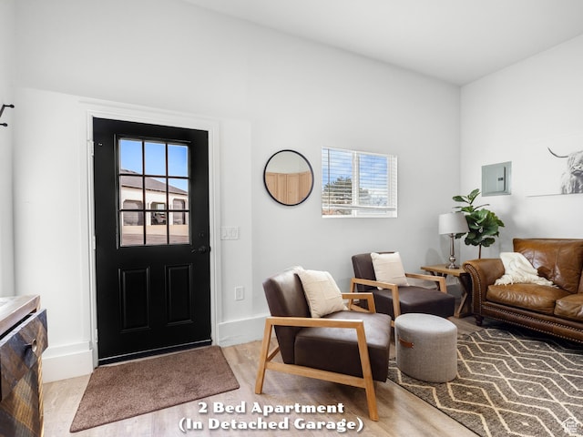 foyer featuring baseboards, electric panel, and plenty of natural light