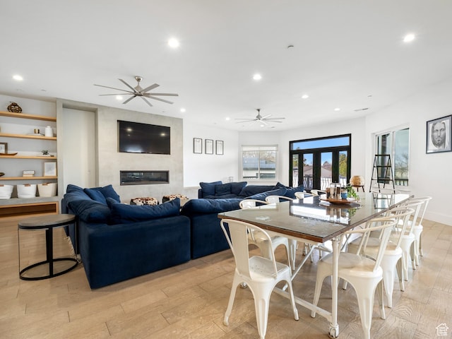 dining space featuring light wood-type flooring, ceiling fan, recessed lighting, and a fireplace