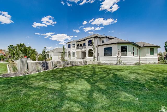 rear view of property with stucco siding and a lawn