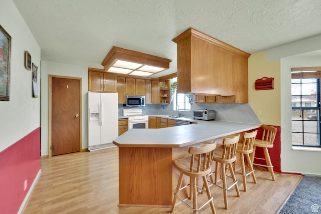 600 E 200 N, Mount Pleasant, UT 84647 - kitchen with a wealth of natural light, white appliances, light countertops, and a peninsula