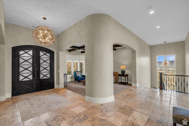 2255 S Hill Rd Unit 14, St George, UT 84790 - foyer with a notable chandelier, baseboards, arched walkways, and stone tile flooring