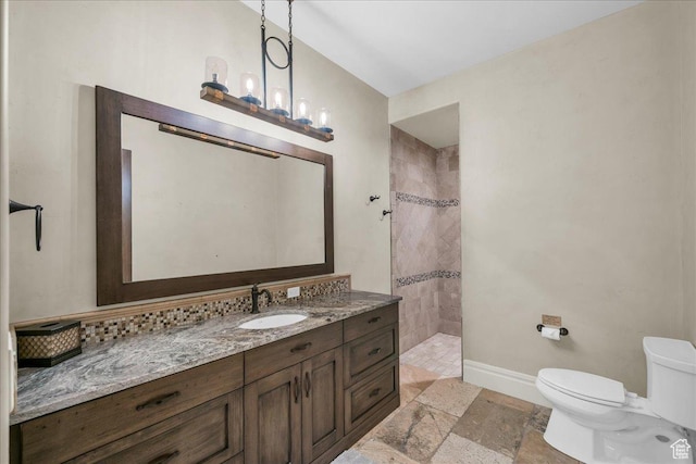2255 S Hill Rd Unit 14, St George, UT 84790 - bathroom with stone finish flooring, baseboards, toilet, tiled shower, and vanity