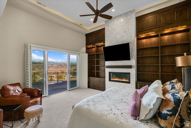 2255 S Hill Rd Unit 14, St George, UT 84790 - bedroom with access to exterior, visible vents, a large fireplace, light colored carpet, and a towering ceiling