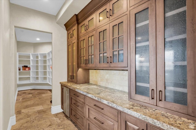 2255 S Hill Rd Unit 14, St George, UT 84790 - kitchen with glass insert cabinets, brown cabinets, tasteful backsplash, and light stone countertops