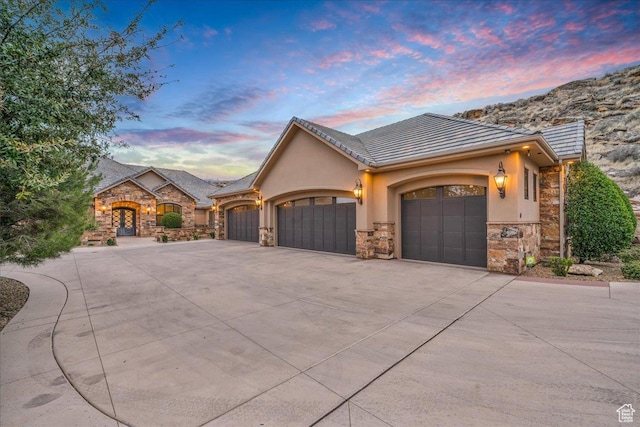 2255 S Hill Rd Unit 14, St George, UT 84790 - view of front of house with stucco siding, stone siding, concrete driveway, an attached garage, and a tiled roof