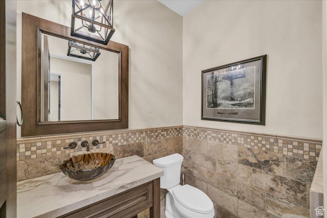 2255 S Hill Rd Unit 14, St George, UT 84790 - bathroom featuring tile walls, a chandelier, a wainscoted wall, toilet, and vanity
