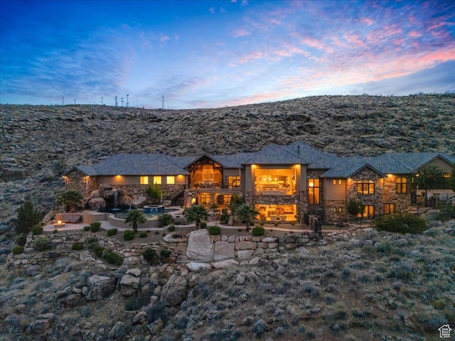 2255 S Hill Rd Unit 14, St George, UT 84790 - back of property at dusk featuring stone siding and a patio area