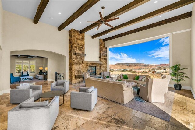 2255 S Hill Rd Unit 14, St George, UT 84790 - living room with arched walkways, a stone fireplace, ceiling fan, and a towering ceiling