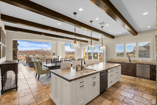 2255 S Hill Rd Unit 14, St George, UT 84790 - kitchen featuring visible vents, a kitchen island with sink, a sink, stone tile flooring, and dishwasher