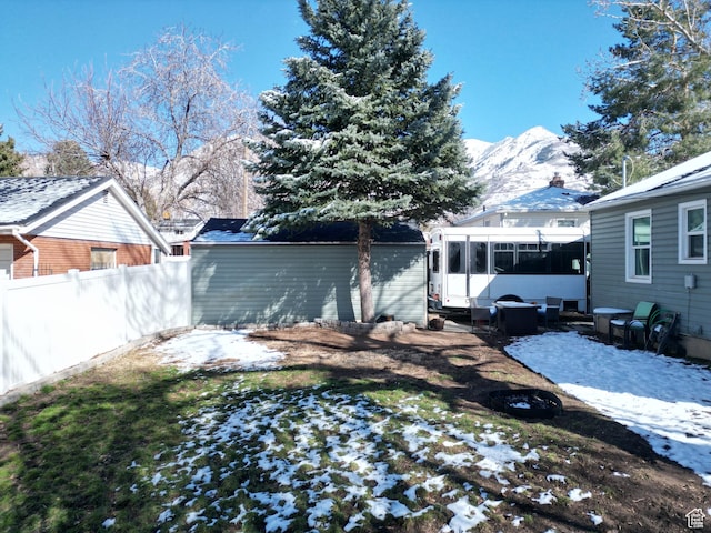 1054 34th St, Ogden, UT 84403 - yard layered in snow featuring a mountain view, a sunroom, and fence
